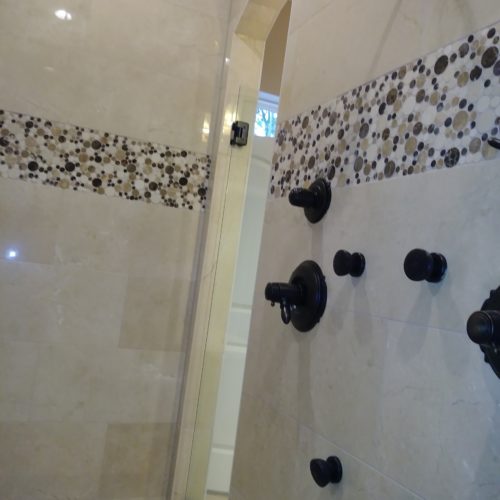 Tiled shower with dark fixtures